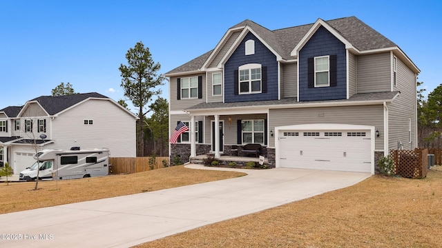 craftsman house featuring fence, concrete driveway, a front yard, covered porch, and a garage