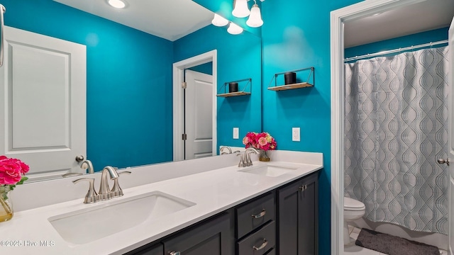 bathroom with a sink, toilet, a shower with shower curtain, and double vanity