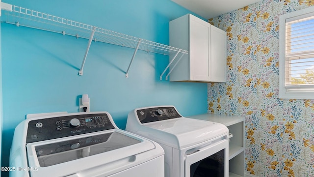 laundry room with washer and dryer, cabinet space, and wallpapered walls