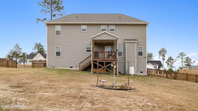 back of house with crawl space, a lawn, a fenced backyard, and stairway