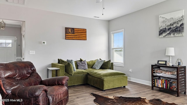 living area with visible vents, baseboards, and wood finished floors