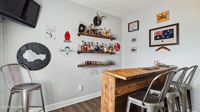 bar featuring a dry bar, dark wood-style floors, and baseboards