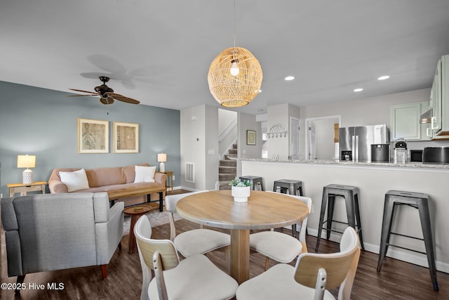 dining area featuring stairway, ceiling fan, baseboards, and dark wood finished floors
