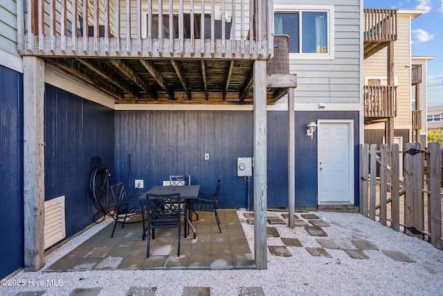 view of patio / terrace with outdoor dining space, a balcony, fence, and visible vents