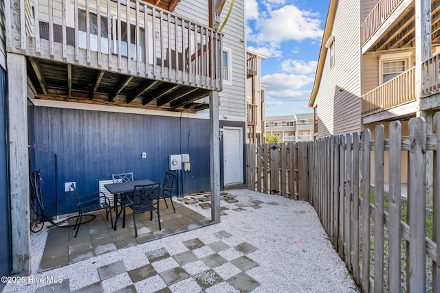 view of patio / terrace with a fenced backyard, outdoor dining area, and a balcony