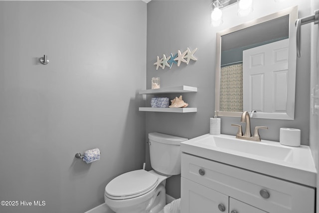 full bathroom featuring baseboards, toilet, and vanity