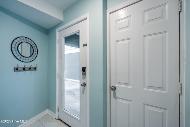 doorway to outside with light tile patterned flooring and baseboards