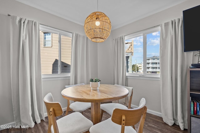 dining space with an inviting chandelier, wood finished floors, and baseboards