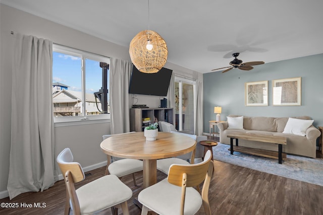 dining space featuring a ceiling fan, wood finished floors, and baseboards