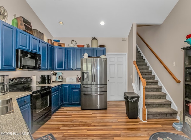 kitchen featuring black appliances, blue cabinetry, recessed lighting, light wood-style floors, and light countertops