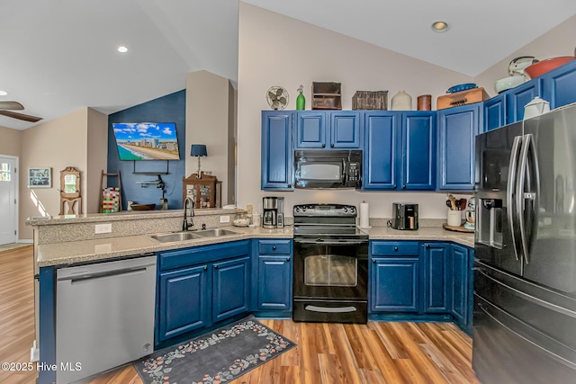 kitchen featuring blue cabinets, black appliances, a sink, a peninsula, and vaulted ceiling