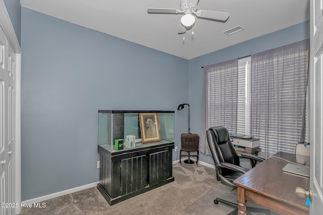 office space with visible vents, baseboards, carpet floors, and a ceiling fan