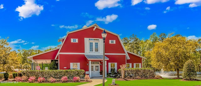 view of front of house featuring french doors, a gambrel roof, and a front yard