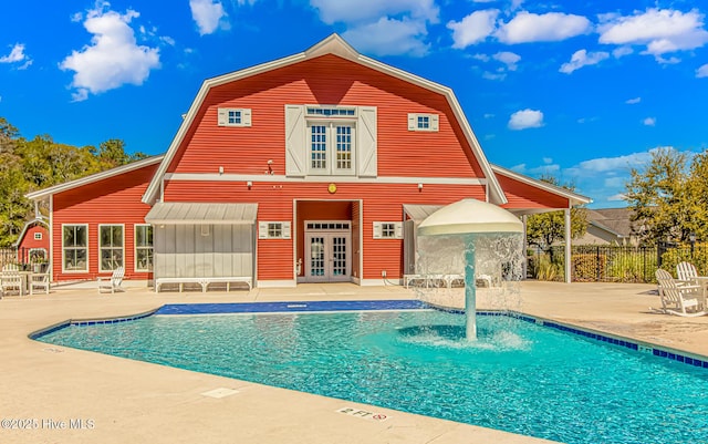 pool with french doors, a patio, and fence