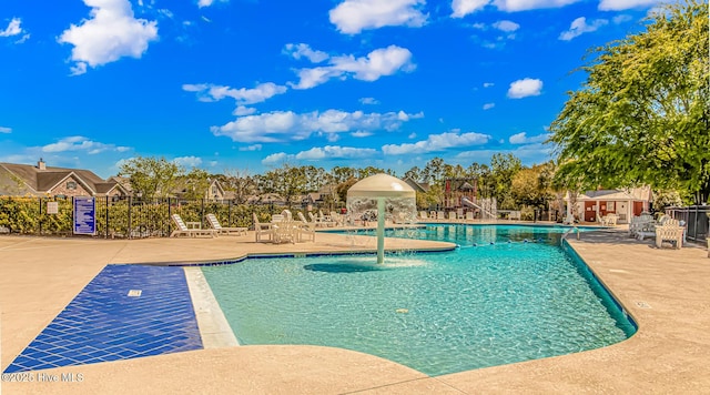 community pool featuring a patio and fence