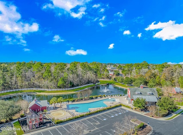 birds eye view of property with a wooded view and a water view