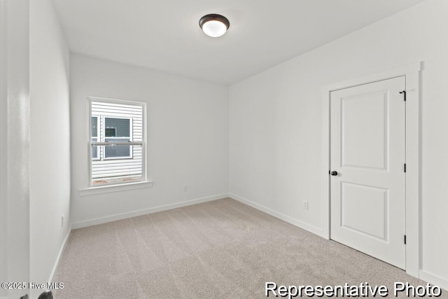 unfurnished room featuring baseboards and carpet