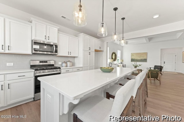 kitchen featuring visible vents, light wood-style flooring, white cabinetry, and stainless steel appliances