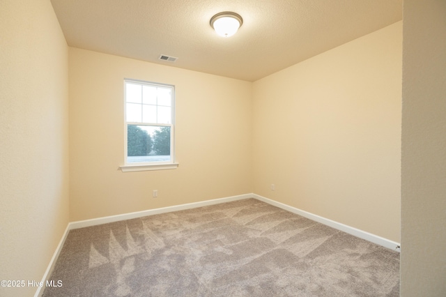 unfurnished room with visible vents, carpet floors, a textured ceiling, and baseboards