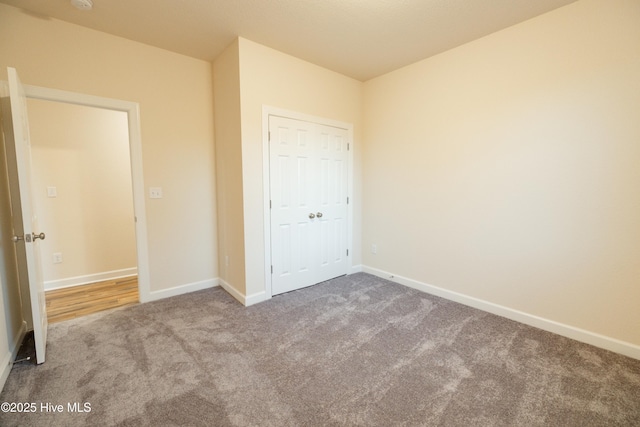 unfurnished bedroom featuring baseboards and carpet