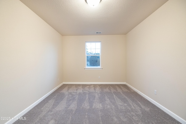 spare room featuring visible vents, baseboards, carpet, and a textured ceiling