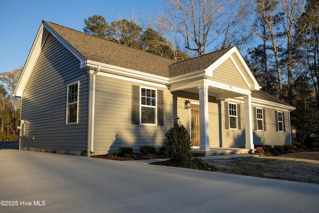 view of front of property featuring driveway and a shingled roof