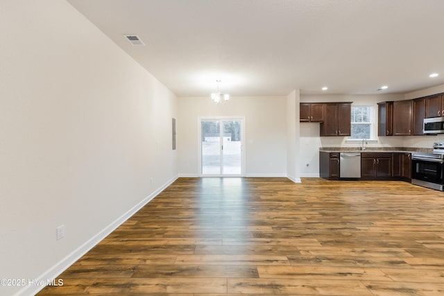 kitchen featuring visible vents, a healthy amount of sunlight, wood finished floors, stainless steel appliances, and a sink