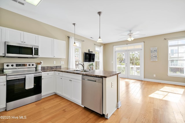 kitchen with a sink, dark countertops, french doors, and stainless steel appliances