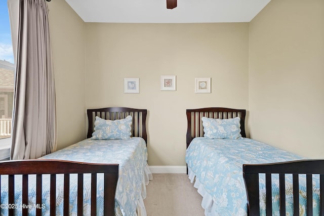 carpeted bedroom with a ceiling fan and baseboards