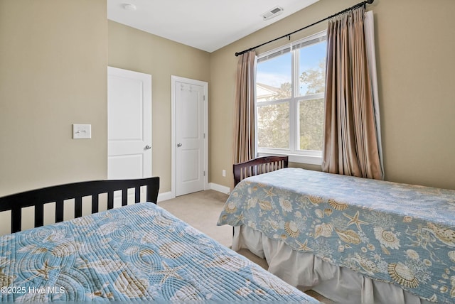 carpeted bedroom with visible vents and baseboards