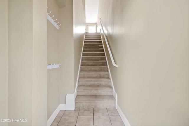 stairway with tile patterned flooring and baseboards