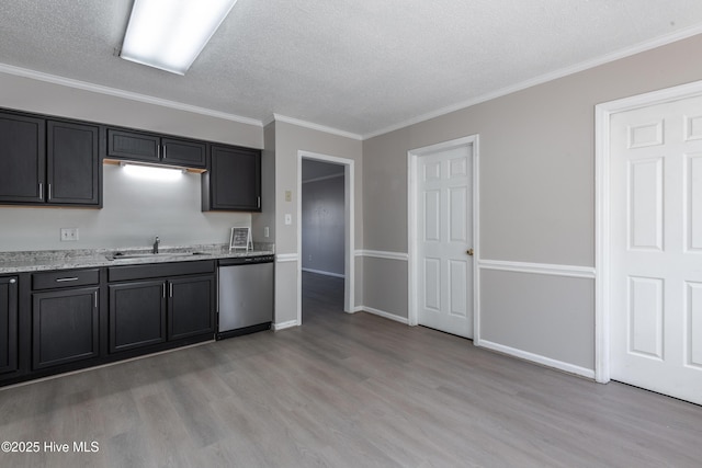 kitchen featuring ornamental molding, a sink, a textured ceiling, light wood finished floors, and dishwasher