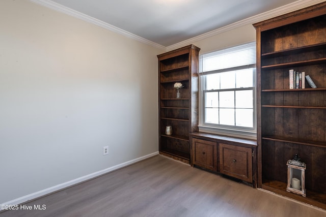 unfurnished room featuring light wood-style flooring, baseboards, and ornamental molding