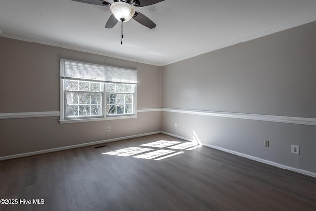 unfurnished room with crown molding, baseboards, and wood finished floors