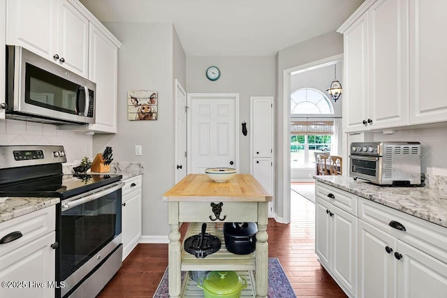 kitchen featuring backsplash, dark wood finished floors, a toaster, appliances with stainless steel finishes, and white cabinetry