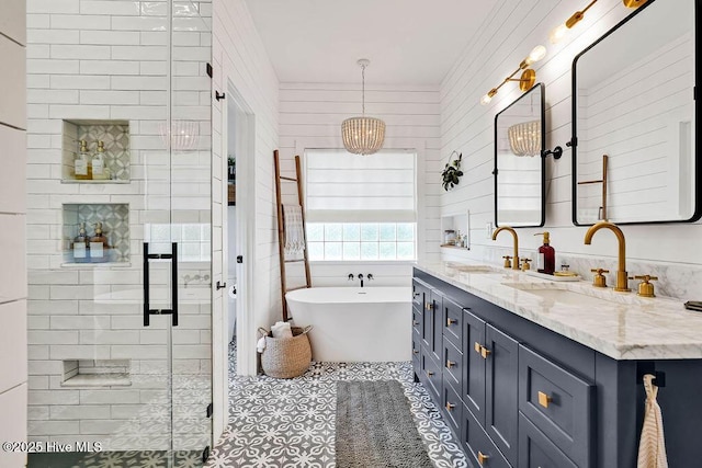 bathroom featuring tile patterned flooring, double vanity, a stall shower, a freestanding tub, and a sink