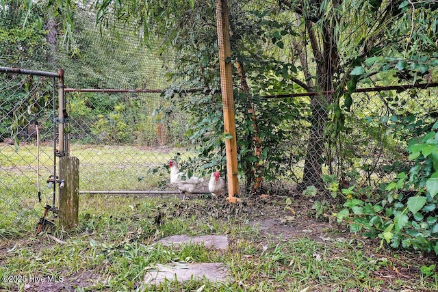 view of gate with fence and a view of trees