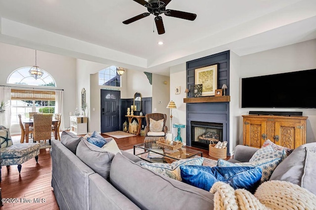 living area featuring recessed lighting, a fireplace, ceiling fan, and wood-type flooring