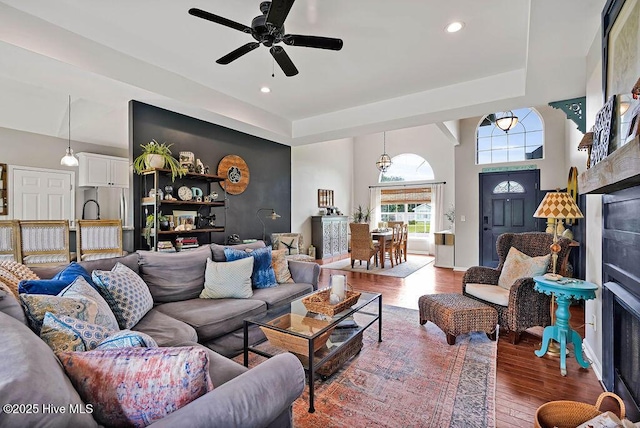 living room with wood finished floors, a high ceiling, recessed lighting, a fireplace, and ceiling fan