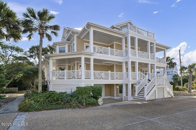 coastal home featuring stairs and a balcony