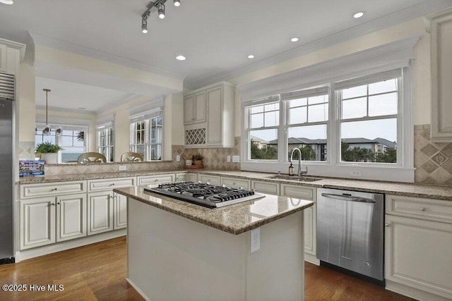 kitchen with ornamental molding, a sink, dark wood finished floors, a center island, and stainless steel appliances