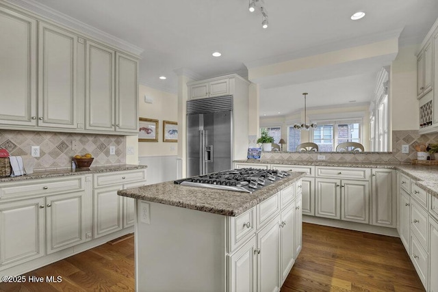 kitchen featuring dark wood-type flooring, crown molding, a kitchen island, and stainless steel appliances