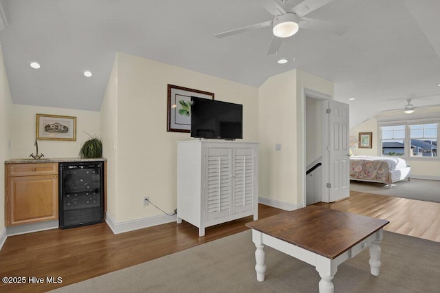 living room with wine cooler, vaulted ceiling, and wood finished floors