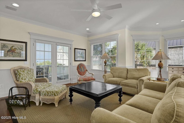 living room featuring a wainscoted wall, crown molding, and wood finished floors