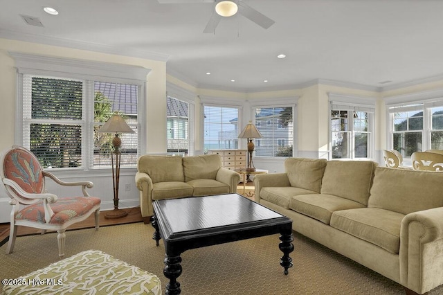 living area featuring a healthy amount of sunlight and ornamental molding