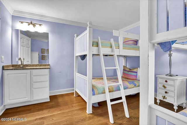 bedroom featuring ornamental molding, baseboards, and wood finished floors