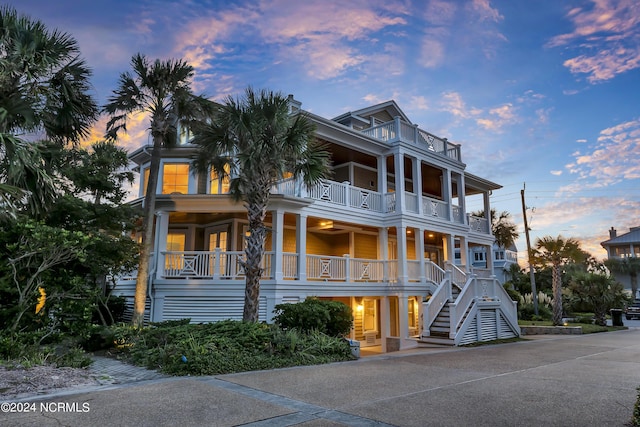 2628 N Lumina Ave, Wrightsville Beach, NC 28480 - coastal home with a balcony, stairway, and covered porch