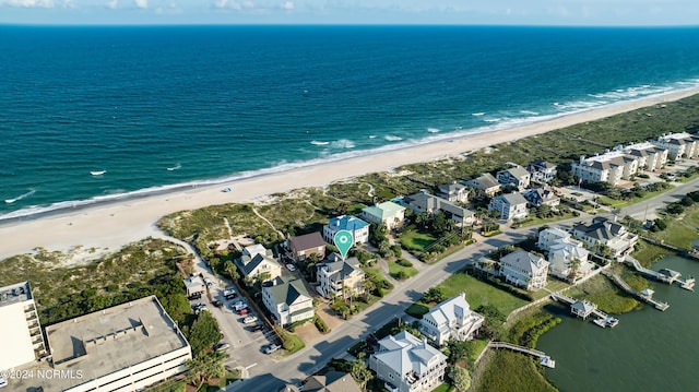 drone / aerial view featuring a beach view, a water view, and a residential view