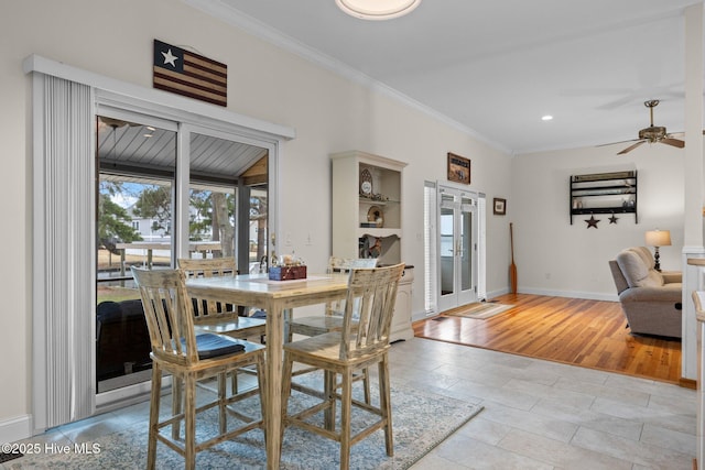 dining space featuring a ceiling fan, baseboards, light wood finished floors, and ornamental molding