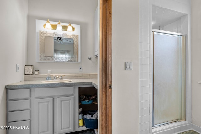 full bathroom with a ceiling fan, vanity, and a shower stall